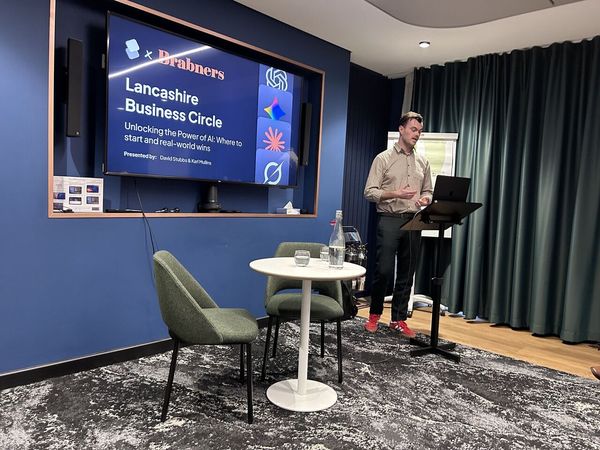 David Stubbs presenting at a lectern. The screen behind him reads: Brabners, Lancashire Business Circle, Unlocking the Power of AI: Where to start and real-world wins, presented by David Stubbs and Karl Mullins.
